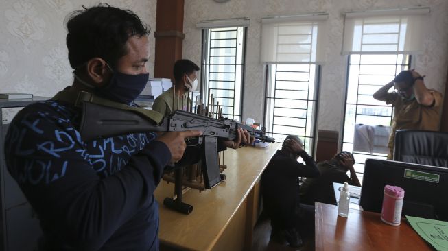 Kelompok teroris menodongkan senjata pada staf kantor Bupati Aceh Besar saat simulasi perang kota di Jantho, Aceh Besar, Aceh, Selasa (6/4/2021). [ANTARA FOTO / Irwansyah Putra]