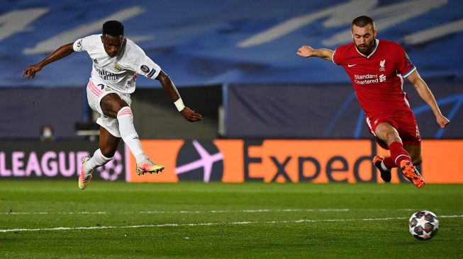 Penyerang Real Madrid Junior mencetak gol melewati bek Liverpool Nathaniel Phillips selama pertandingan sepak bola perempat final leg pertama Liga Champions antara Real Madrid melawan Liverpool di Estadio Alfredo Di Stefano, Rabu (7/4/2021) dini hari WIB. GABRIEL BOUYS / AFP