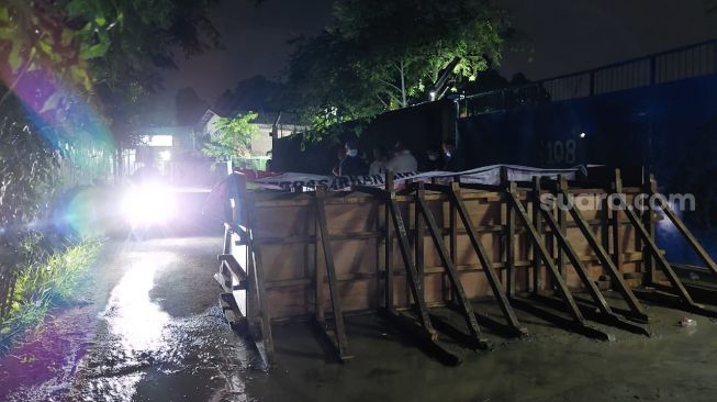 Dinding yang memblokir akses menuju kawasan pergudangan di Jalan Kemuliaan, Cipondoh, Kota Tangerang, Rabu (7/4/2021) malam. [Suara.com/Muhammad Jehan Nurhakim]