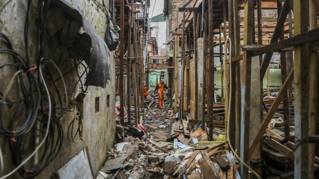 Pekerja menyelesaikan pembangunan rumah panggung di kawasan Kebon Pala, Jakarta, Rabu (7/4/2021).  ANTARA FOTO/Galih Pradipta