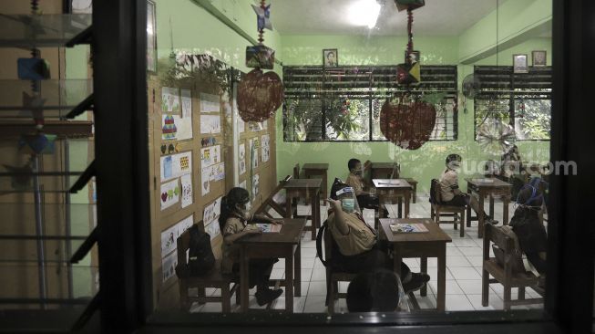 Sejumlah murid mengikuti uji coba pembelajaran tatap muka di SD Negeri Kenari 08 Pagi, Jakarta, Rabu (7/4/2021). [Suara.com/Angga Budhiyanto]