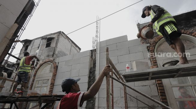 Pekerja menyelesaikan revitalisasi rumah warga di Kampung Kwitang, Jakarta, Kamis (8/4/2021). [Suara.com/Angga Budhiyanto]