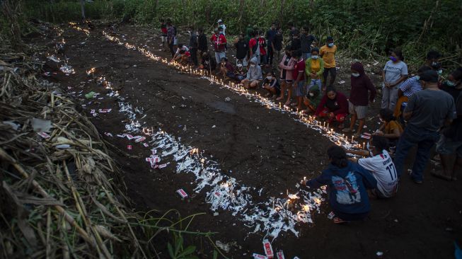 Sejumlah warga menyalakan lilin saat berziarah di tempat pemakaman massal korban tanah longsor di Desa Nelelamadike, Kecamatan Ile Boleng, Kabupaten Flores Timur, Nusa Tenggara Timur (NTT), Rabu (7/4/2021).  ANTARA FOTO/Aditya Pradana Putra