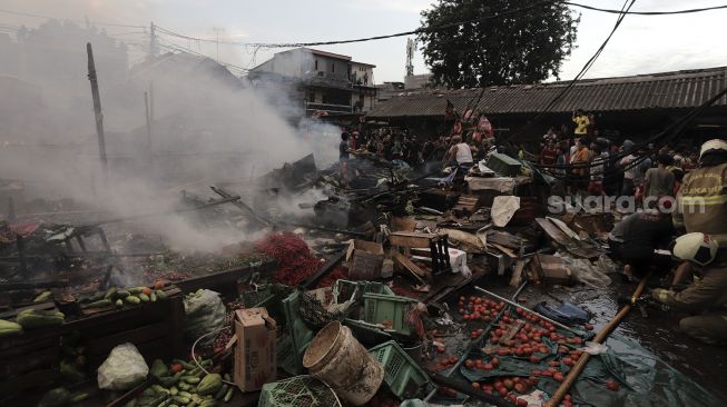 Warga menyaksikan kebakaran yang melanda Pasar Lontar atau Pasar Kambing di Jalan Sabeni, Tanah Abang, Jakarta, Kamis (8/4/2021). [Suara.com/Angga Budhiyanto]