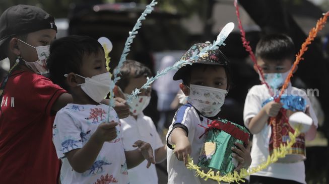 Sejumlah siswa taman kanak-kanak (TK) menunjukkan miniatur beduk buatannya saat mengikuti proses pembelajaran secara Drive in Learning (DRIL) di area parkir Padepokan Pencak Silat Indonesia, Jakarta, Kamis (8/4/2021). [Suara.com/Angga Budhiyanto]