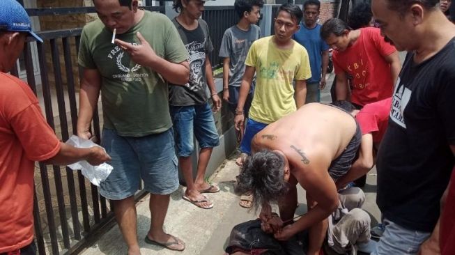 Pelaku perampokan babak belur dimassa usai aksinya berhasil digagalkan warga Jalan Suka Bakti 1, Serua, Ciputat, Kota Tangsel, Kamis (8/4/2021). [Ist]