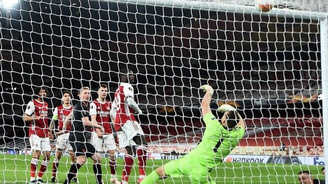 Kiper Arsenal Bernd Leno (kedua kanan) gagal mengamankan sundulan bek Slavia Praha Tomas Holes (kanan) yang memaksakan skor imbang dalam leg pertama perempat final Liga Europa di Stadion Emirates, London, Inggris, Kamis (8/4/2021) waktu setempat. (ANTARA/REUTERS/Dylan Martinez)