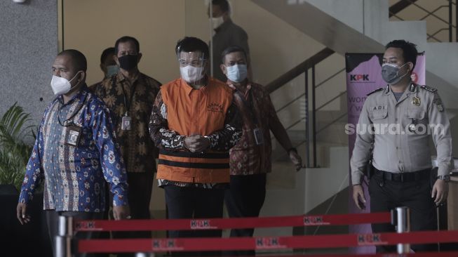 Bupati Bandung Barat Aa Umbara Sutisna (tengah) berjalan keluar usai menjalani pemeriksaan di Gedung Merah Putih KPK, Jakarta, Jumat (9/4/2021). [Suara.com/Angga Budhiyanto]