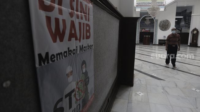 Jamaah berjalan di dalam Masjid Cut Meutia, Jakarta, Sabtu (10/4/2021). [Suara.com/Angga Budhiyanto]