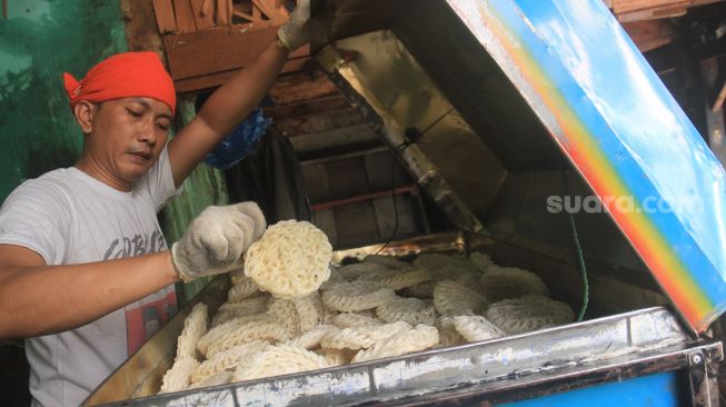 Pedagang menata kerupuk produksi UMKM Melati di kawasan Menteng Atas, Jakarta, Sabtu (10/4). [Suara.com/Oke Atmaja]
