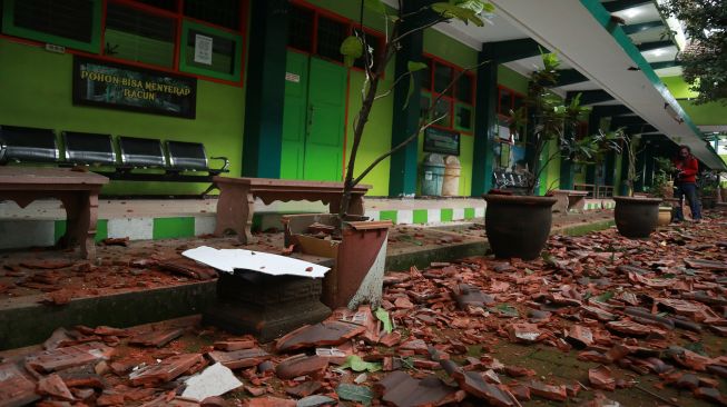 Seorang warga melintas di depan bangunan sekolah yang rusak akibat gempa di SMK Negeri 1 Turen, Malang, Jawa Timur, Sabtu (10/4/2021). Gempa yang mengguncang kawasan Malang dan sekitarnya membuat sejumlah bangunan rusak. ANTARA FOTO/Bayu
