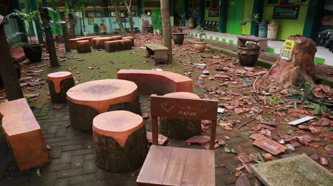 Reruntuhan genting sekolah terlihat memenuhi halaman sekolah yang rusak akibat gempa di SMK Negeri 1 Turen, Malang, Jawa Timur, Sabtu (10/4/2021). ANTARA FOTO/Bayu
