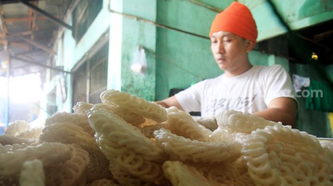 Pedagang menata kerupuk produksi UMKM Melati di kawasan Menteng Atas, Jakarta, Sabtu (10/4). [Suara.com/Oke Atmaja]
