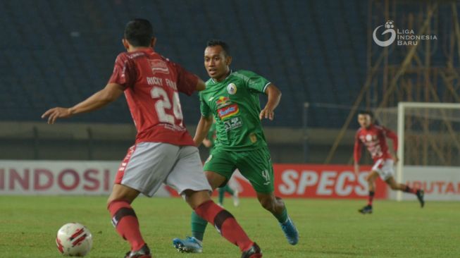 Bek Bali United, Ricky Fajrin (kiri) coba mempertahankan bola dari gangguan penyerang sayap PSS Sleman Irfan Jaya dalam laga perempat final Piala Menpora di Stadion Si Jalak Harupat, Bandung, Senin (12/4/2021) malam WIB. [Dok. Liga Indonesia Baru]