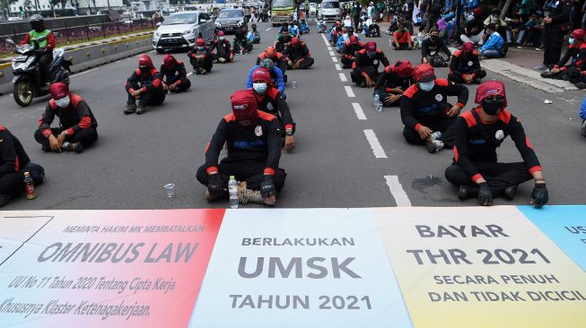 Sejumlah buruh yang tergabung dalam Konfederasi Serikat Pekerja Indonesia (KSPI) berunjuk rasa di kawasan Patung Kuda, Jakarta, Senin (12/4/2021). ANTARA FOTO/Hafidz Mubarak 