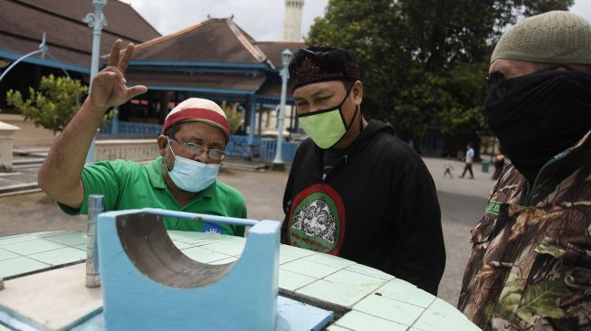 Pengunjung melihat Jam Istiwa atau Jam Bencet yang berada di halaman Masjid Agung Solo, Jawa Tengah, Selasa (13/4/2021).  ANTARA FOTO/Maulana Surya
