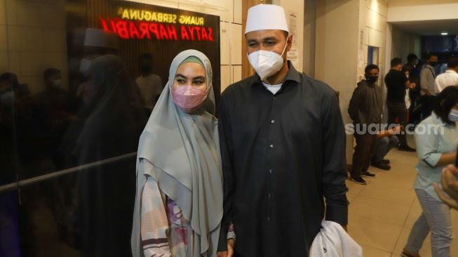 Aktris Kartika Putri ditemani sang suami, Habib Usman bin Yahya usai menjalani mediasi di Polda Metro Jaya, Jakarta Selatan, Rabu (14/4/2021). [Suara.com/Alfian Winanto]