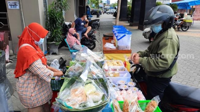 Pedagang makanan pecel, Ndari, melayani pembeli di pasar tiban di timur Pasar Bantul, Rabu (14/4/2021). - (SuaraJogja.id/Muhammad Ilham Baktora)