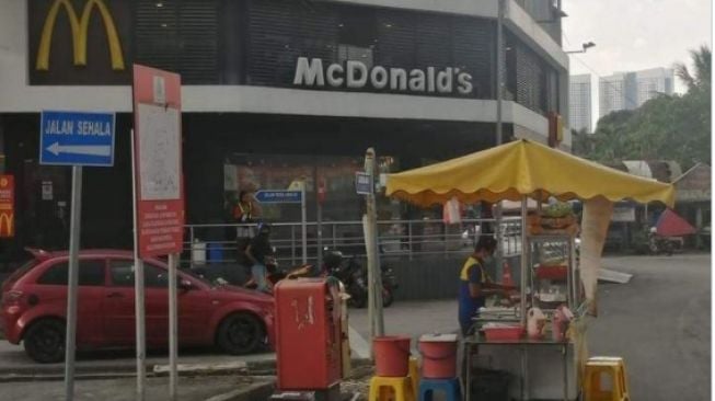 Pedagang burger berjualan di depan McD (twitter.com/@craz33sufri)