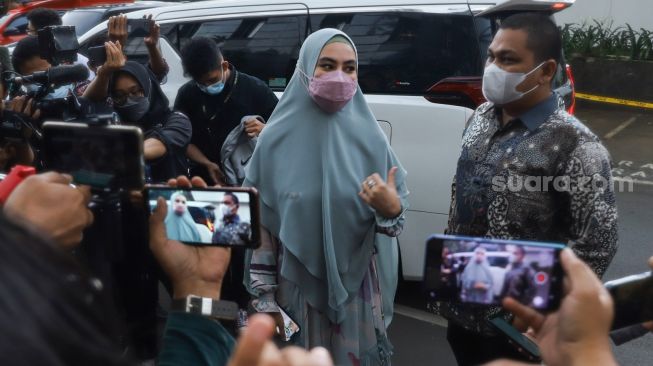 Aktris Kartika Putri menyapa awak media saat tiba di Polda Metro Jaya, Jakarta Pusat, Rabu (14/4/2021). [Suara.com/Alfian Winanto]