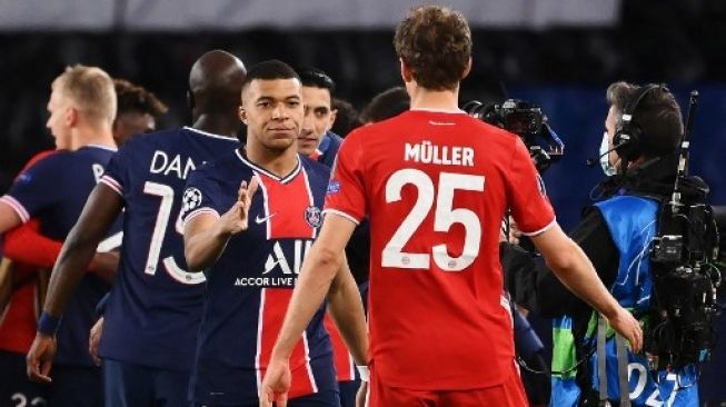 Pemain Paris Saint-Germain Kylian Mbappe (kiri) berjabat tangan dengan striker Bayern Munich Thomas Mueller setelah PSG memenangi babak perempat final Liga Champions berkat gol tandang usai laga di Parc des Princes stadium, Paris. FRANCK FIFE / AFP