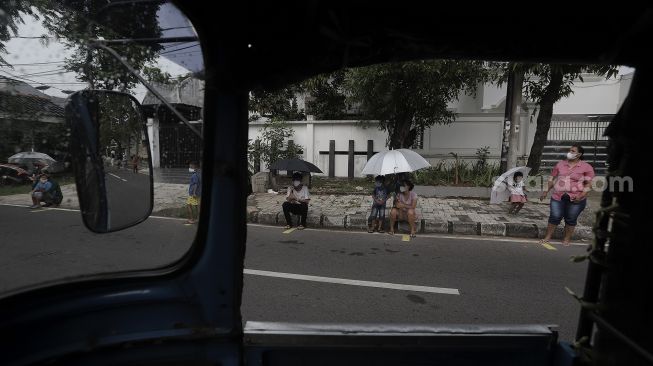 Sejumlah warga mengantre untuk mendapatkan takjil gratis di jalan Cempaka Putih Tengah XXI, Jakarta, Kamis (15/4/2021). [Suara.com/Angga Budhiyanto]