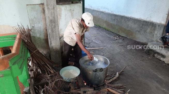 Seorang warga memasak beras menjadi bubur untuk menu berbuka puasa di Masjid Sabilurrosyad atau Masjid Kauman Bantul, Pedukuhan Kauman, Kalurahan Wijirejo, Kapanewon Pandak, Kabupaten Bantul, Kamis (15/4/2021). - (SuaraJogja.id/Muhammad Ilham Baktora)