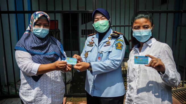 Kepala Lapas Perempuan Kelas IIA Kota Bandung Prihartati (tengah) memberikan KTP elektronik kepada perwakilan warga binaan di Lapas Perempuan Kelas IIA, Bandung, Jawa Barat, Kamis (15/4/2021). ANTARA FOTO/Raisan Al Farisi