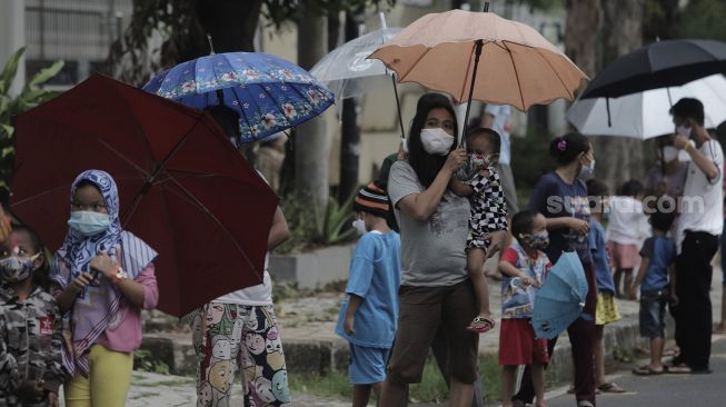 Sejumlah warga mengantre untuk mendapatkan takjil gratis di jalan Cempaka Putih Tengah XXI, Jakarta, Kamis (15/4/2021). [Suara.com/Angga Budhiyanto]