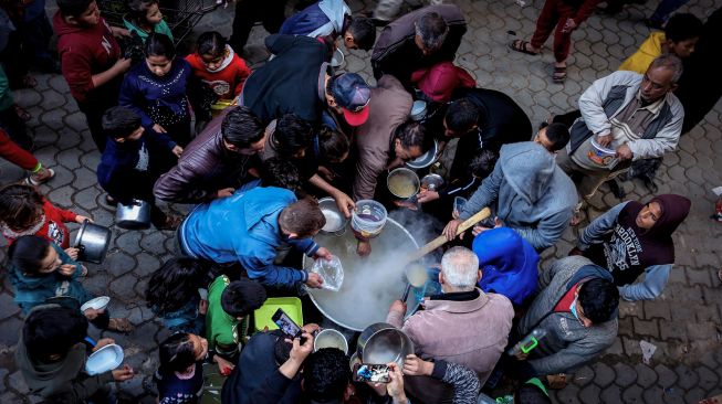 Warga mengantri untuk mendapatkan sup gratis untuk berbuka puasa di tengah pandemi Covid-19 di Gaza, Palestina, Rabu (14/4).  MOHAMMED ABED / AFP
