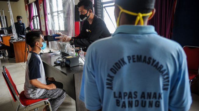 Seorang warga binaan menjalani perekaman KTP elektronik di Lembaga Pembinaan Khusus Anak (LPKA), Bandung, Jawa Barat, Kamis (15/4/2021).  ANTARA FOTO/Raisan Al Farisi
