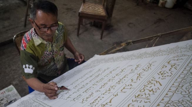 Perajin menyelesaikan pembuatan batik motif ayat Al Quran di Mahkota Batik Laweyan, Solo, Jawa Tengah, Jumat (16/4/2020). ANTARA FOTO/Mohammad Ayudha