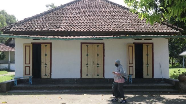 Pengunjung melintas di depan rumah pendiri Nahdlatul Ulama (NU) KH Hasyim Asy'ari di kawasan Pondok Pesantren Kapurejo, Kediri, Jawa Timur, Sabtu (17/4/2021).  ANTARA FOTO/Prasetia Fauzani