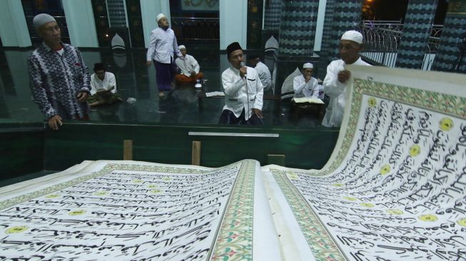 Umat Islam bertadarus menggunakan Al Quran raksasa di Masjid Baiturrahman, Banyuwangi, Jawa Timur, Jumat (16/4/2021).  ANTARA FOTO/Budi Candra Setya