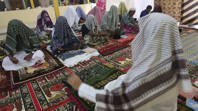 Jamaah suluk menutupi kepalanya dengan selendang dan surban saat mengikuti zikir di Pondok Pesantren Nurul Huda, Desa Reusak, Samatiga, Aceh Barat, Aceh, Sabtu (17/4/2021). [ANTARA FOTO/Syifa Yulinnas]