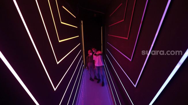 Pengunjung berswafoto di salah satu instalasi seni di MoJA Museum, Stadion Utama Gelora Bung Karno, Jakarta, Minggu (18/4/2021). [Suara.com/Angga Budhiyanto]