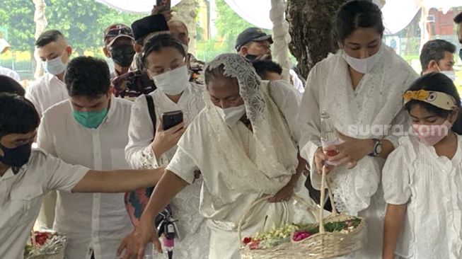 Aktris Dian Sastrowardoyo bersama keluarga menabur bunga di pusara ayah mertuanya, Adiguna Sutowo di Tempat Pemakaman Umum (TPU) Tanah Kusir, Jakarta, Minggu (18/4/2021). [Suara.com/Evi Ariska]