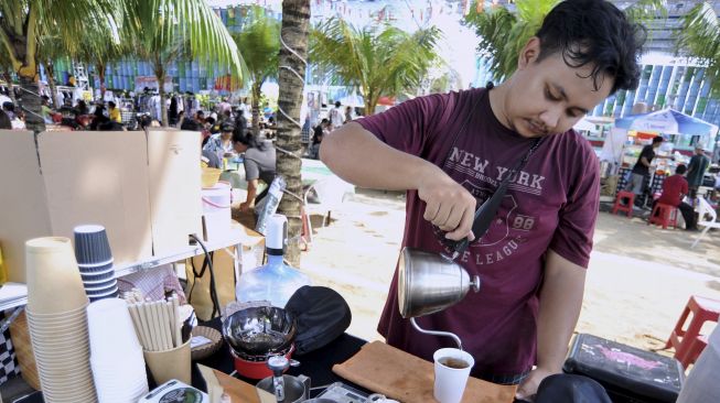 Pelaku usaha menyajikan minuman di gelas kertas saat kegiatan "Minggu Tanpa Plastik" di Denpasar, Bali, Minggu (18/4/2021). [ANTARA FOTO/Fikri Yusuf]