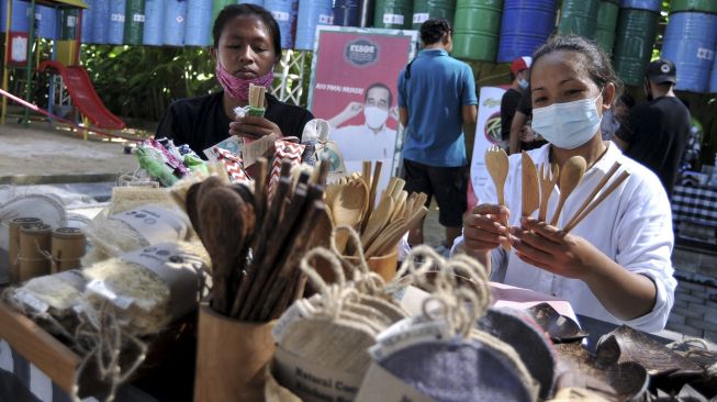 Perajin menunjukkan peralatan makan ramah lingkungan yang dijual saat kegiatan "Minggu Tanpa Plastik" di Denpasar, Bali, Minggu (18/4/2021). [ANTARA FOTO/Fikri Yusuf]