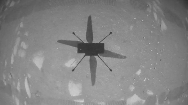 Bayangan Ingenuity di permukaan Mars. Ingenuity helikopter NASA berhasil terbang di Mars, pada Senin (19/4/2021). [AFP/NASA]