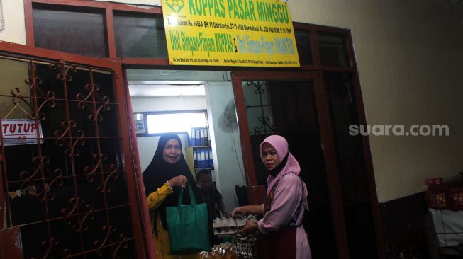 Pedagang menunjukkan sembako yang telah dibagikan di Pasar Minggu, Jakarta Selatan, Selasa (20/4/2021).  [Suara.com/Dian Latifah]