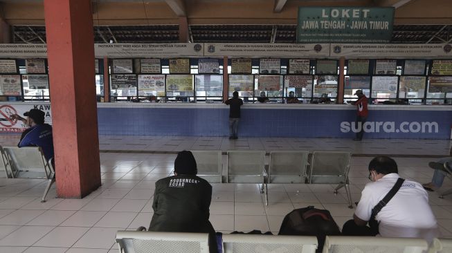 Calon penumpang menunggu kedatangan bus di Terminal Kampung Rambutan, Jakarta, Selasa (20/4/2021). [Suara.com/Angga Budhiyanto]