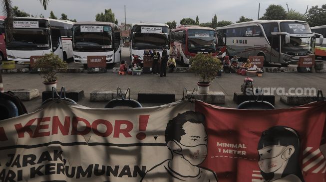 Sejumlah bus antar kota antar provinsi (AKAP) terparkir menunggu penumpang di Terminal Kampung Rambutan, Jakarta, Selasa (20/4/2021). [Suara.com/Angga Budhiyanto]