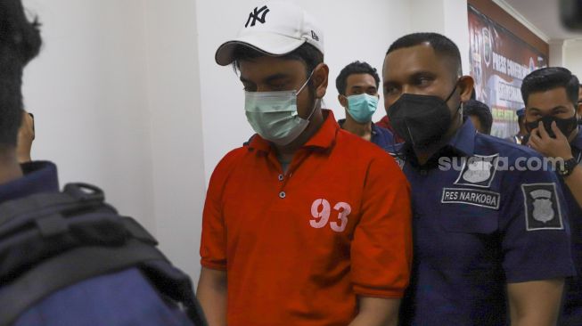 Pesinetron Rio Reifan dibawa kembali ke ruang tahanan usai dihadirkan saat rilis kasus narkoba yang menjeratnya di Polres Metro Jakarta Pusat, Rabu (21/4/2021). [Suara.com/Alfian Winanto]