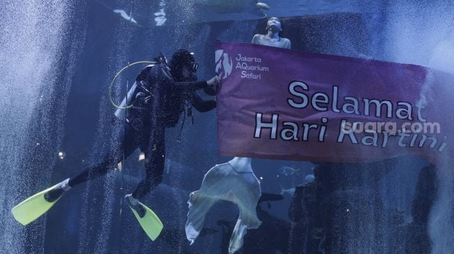 Penyelam menyapa pengunjung saat peringatan Hari Kartini di Jakarta Aquarium dan Safari, Jakarta, Rabu (21/4/2021). [Suara.com/Angga Budhiyanto]