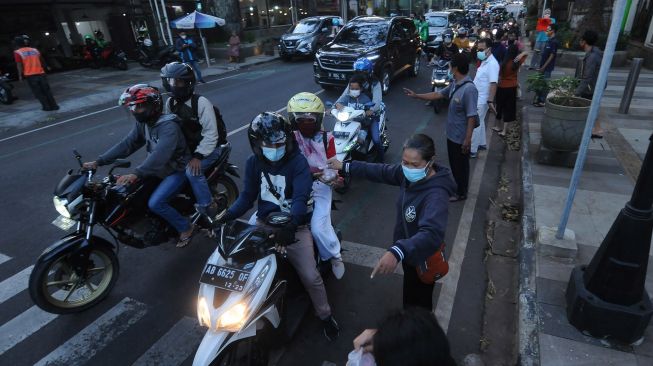 Umat Katolik membagikan makanan untuk berbuka puasa (takjil) kepada pengendara kendaraan di depan Gereja Katolik Santo Paulus Miki, Salatiga, Jawa Tengah, Rabu (21/4/2021). ANTARA FOTO/Aloysius Jarot Nugroho