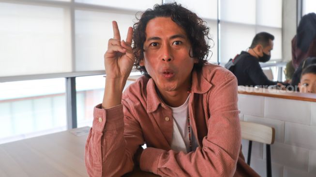 Penyanyi Budi Doremi berpose didepan kamera saat ditemui di Kemang, Jakarta Selatan, Rabu (21/4/2021). [Suara.com/Alfian Winanto]