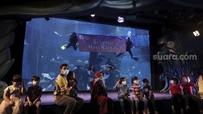 Pengunjung berfoto bersama penyelam saat peringatan Hari Kartini di Jakarta Aquarium dan Safari, Jakarta, Rabu (21/4/2021). [Suara.com/Angga Budhiyanto]