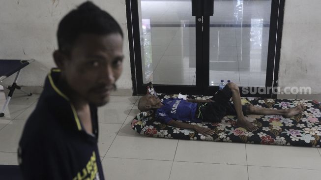 Dua orang Penyandang Masalah Kesejahteraan Sosial (PMKS) beristirahat di tempat hunian sementara GOR Pasar Minggu, Jakarta, Rabu (21/4/2021). [Suara.com/Angga Budhiyanto]