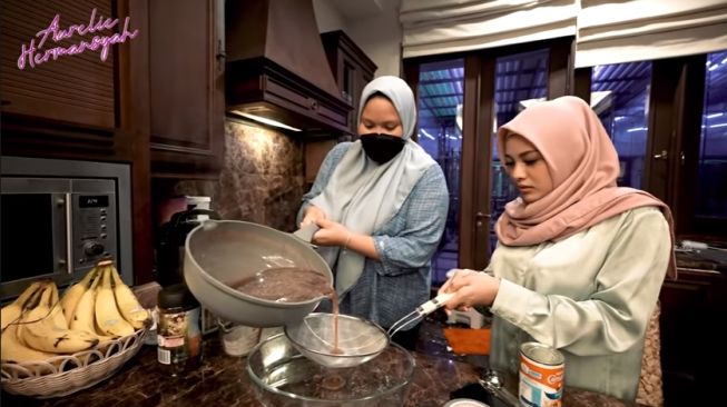 Potret Aurel memasak untuk Bunda Maia. [YouTube/Aurel Hermansyah]